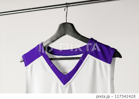 White basketball jersey hanging against white background White basketball jersey hanging against white background 117342428