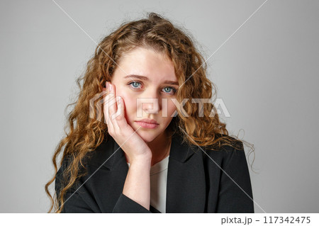Young Woman With Curly Hair Expressing Concern 117342475