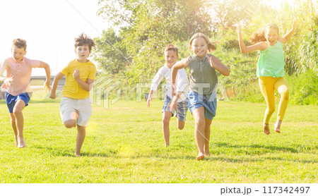 Group of five happy children jogging in a park Group of five happy children jogging in a park 117342497