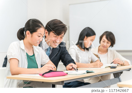 塾・学校の教室で先生に勉強を教わる小学生・中学生・高校生の子供（女の子） 117342667