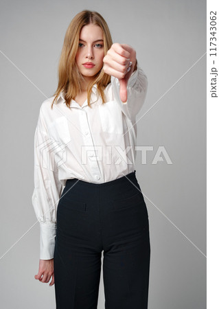 Young Woman in White Shirt Pointing Finger Down Dislike 117343062