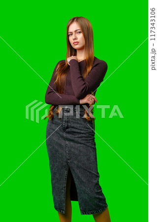 Young Woman Posing With Arms Crossed Against Green Screen Young Woman Posing With Arms Crossed Against Green Screen 117343106