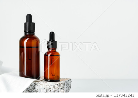 Two Amber Glass Dropper Bottles on White Background Two Amber Glass Dropper Bottles on White Background 117343243