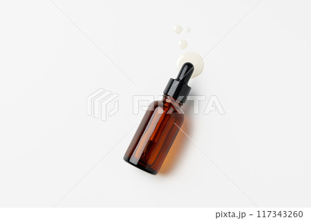 Brown Glass Dropper Bottle With White Liquid on a White Background Brown Glass Dropper Bottle With White Liquid on a White Background 117343260