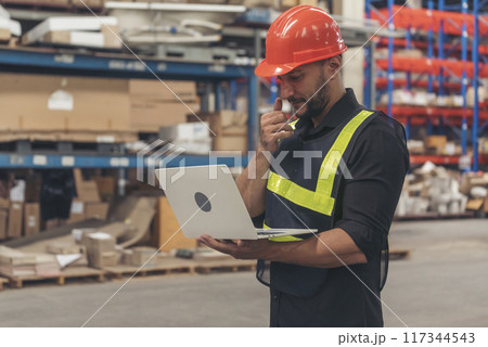 Hispanic men hands using typing laptop computer Warehouse management logistics counting checking products on inventory shelf. Engineer Man hands checklist stock control computer program in storage 117344543