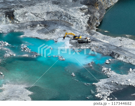 Open pit mine industry. Limestone quarry with backhoe and truck in operation. Heavy machinery in mining industry and construction material supply. Landscape of resource extraction in a industrial site 117344682