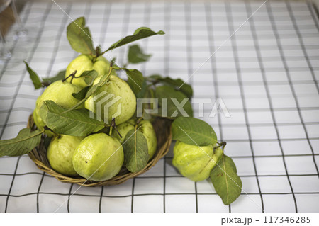 Green guava in the bamboo basket on the table. Green guava in the bamboo basket on the table. 117346285