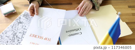 Military man holding in hands secret plans of Ukrainian counteroffensive operation 117346805