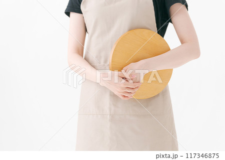 エプロンをつけた女性店員の手元 117346875