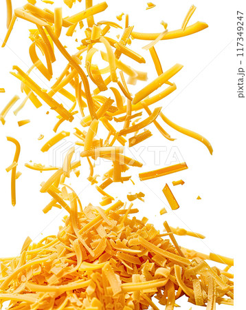 Close up of grated cheddar cheese falling and piling up on white background, capturing dynamic motion with cheese shreds in mid air. Vibrant yellow color of shredded cheese pieces. Ai generation 117349247
