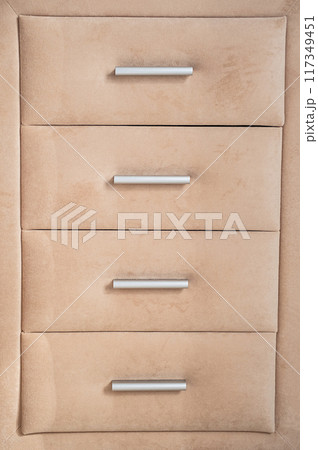 Beige cushioned dresser featuring drawers with sleek silver handles. Beige cushioned dresser featuring drawers with sleek silver handles. 117349451