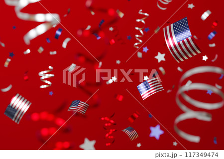Vibrant image of American flag-themed confetti falling against a bright red background, perfect for festive occasions like Independence Day, Memorial Day, or political events. 3D render. 117349474