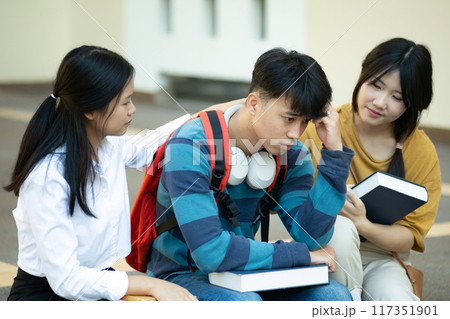 Friends comforting stressed student on campus 117351901