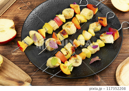 Plate of mixed fruits on skewers. 117352208
