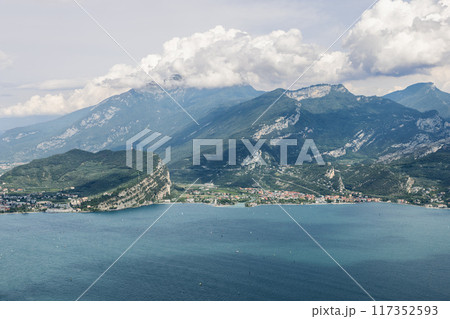 Tranquil waters of Lake Garda complement the picturesque town of Torbole with Monte Baldo looming 117352593