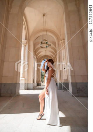 Bride, Wedding, Photography: Woman in white dress poses in a courtyard during a wedding photoshoot. Bride, Wedding, Photography: Woman in white dress poses in a courtyard during a wedding photoshoot. 117353641