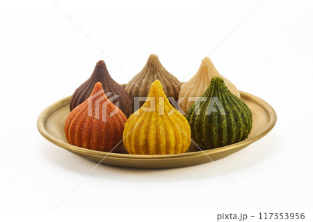 Ganesh Chaturthi Festival. Colorful Modaks Indian sweet dumpling on Plate Ganesh Chaturthi Festival. Colorful Modaks Indian sweet dumpling on Plate 117353956