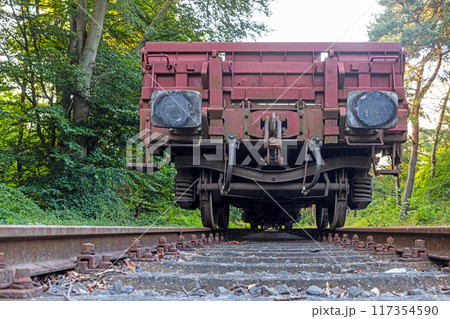 Picture of an cargo railroad car standing on a track photographed from the ground perspective Picture of an cargo railroad car standing on a track photographed from the ground perspective 117354590