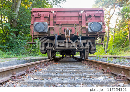 Picture of an cargo railroad car standing on a track photographed from the ground perspective Picture of an cargo railroad car standing on a track photographed from the ground perspective 117354591