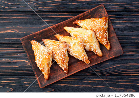 Homemade triangle puff pastry with meat on rustic background . Samosa Homemade triangle puff pastry with meat on rustic background . Samosa 117354896
