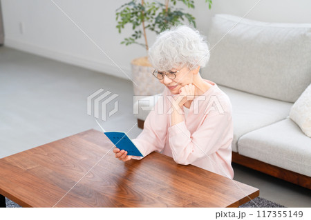年金手帳を確認するシニア女性	 117355149