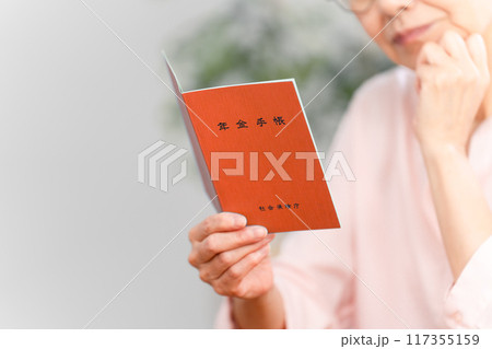 年金手帳を確認するシニア女性	 117355159