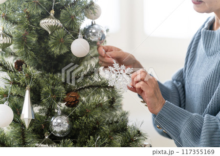 クリスマスツリーのオーナメントを飾るシニア女性 クリスマスツリーのオーナメントを飾るシニア女性 117355169