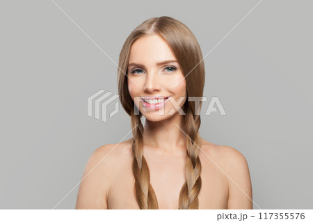 Happy young healthy woman with pigtail hairstyle and natural make-up on white background 117355576