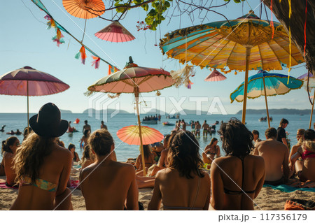 Summertime beachside music festival vibes with colorful umbrellas, live entertainment, and festive atmosphere for holidaymakers and leisure seekers 117356179