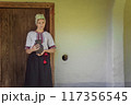 A Traditional Woman in a Beautiful Folk Costume Holding a Decorative Pot in Her Hands 117356545
