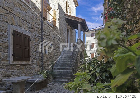 a narrow alley with steps leading up to a door and a stone building 117357429