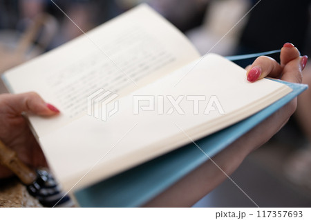電車で本を読む女性の手元 電車で本を読む女性の手元 117357693