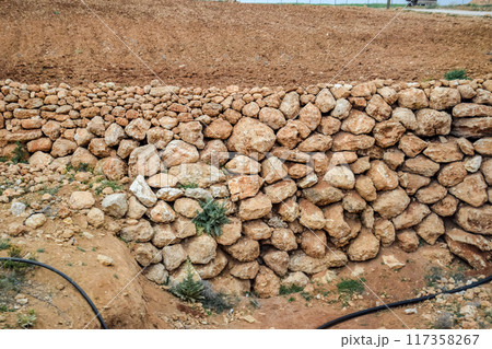 Cobblestones to strengthen the slope near road. Cobblestones to strengthen the slope near road. 117358267