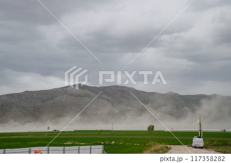 puffs of steam from hot spring near the mountains 117358282