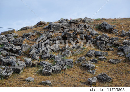 Huge blocks of a wall destroyed by an earthquake. Ruins of the city of Hierapolis Huge blocks of a wall destroyed by an earthquake. Ruins of the city of Hierapolis 117358684