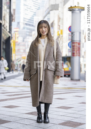 ロングコートを着たカメラ目線で笑顔の20代の女性　全身　ポートレート 117359664
