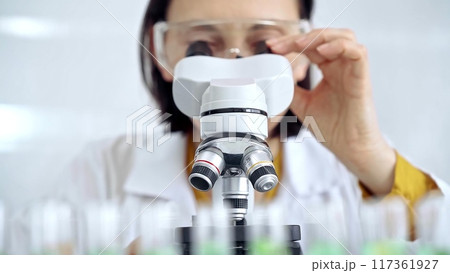 Woman scientist using microscope in laboratory. Microbiology science concept 117361927