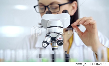 Woman scientist using microscope in laboratory. Microbiology science concept 117362186