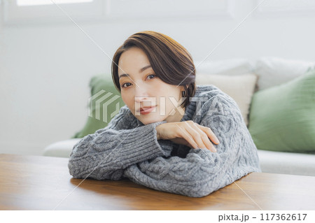 部屋でリラックスするニットの女性 117362617