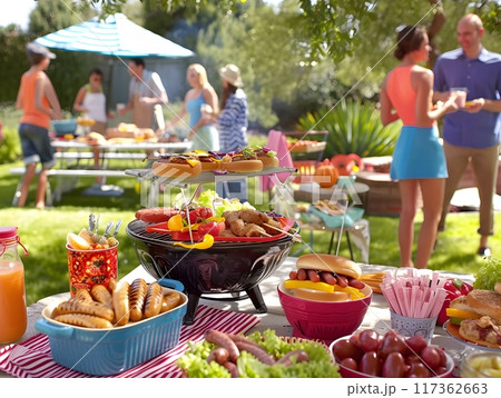 Outdoor Gathering with Food Spread on Table in a Lush Green Park Outdoor Gathering with Food Spread on Table in a Lush Green Park 117362663