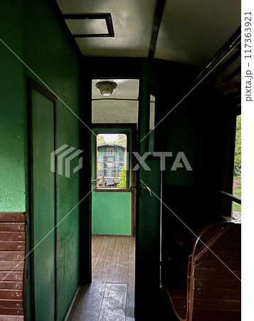 Interior of a train wagon with a green door and a window 117363921