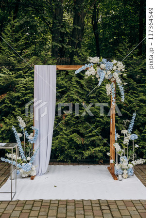 Elegant outdoor wedding arch with floral decorations for a romantic garden ceremony Elegant outdoor wedding arch with floral decorations for a romantic garden ceremony 117364549