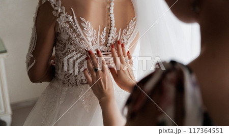 Bridal gown close-up, showcasing intricate lace details as the bride prepares for her special day 117364551