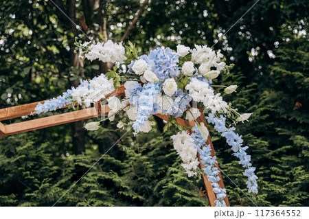 Close-up of a beautifully decorated floral wedding arch for an elegant outdoor ceremony Close-up of a beautifully decorated floral wedding arch for an elegant outdoor ceremony 117364552