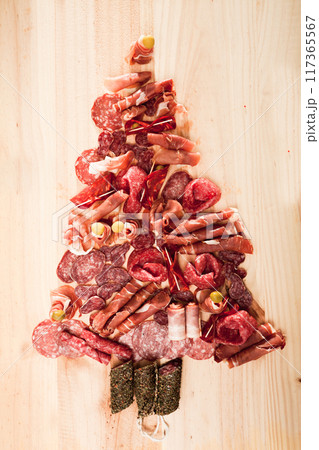 Christmas tree made of sausage on a background of a wooden wall Christmas tree made of sausage on a background of a wooden wall 117365567