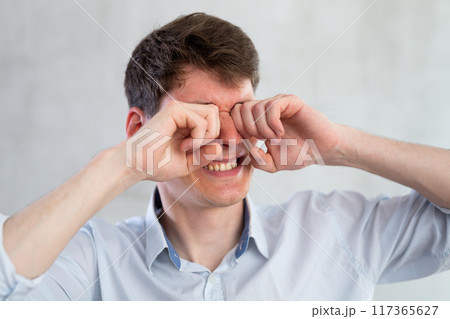 Man scretching itchy eyes on gray background 117365627