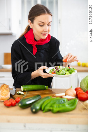 Female cook preparing food in kitchen Female cook preparing food in kitchen 117366129