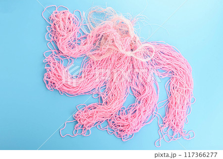 Top view of fishing line threads with pink beads on blue background. 117366277
