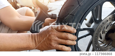 Technician patching a tire motorcycle tires 117366868