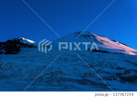 view of snowy peaks of mount Elbrus in the early dawn rays. Elbrus is the highest peak in Europe 117367259